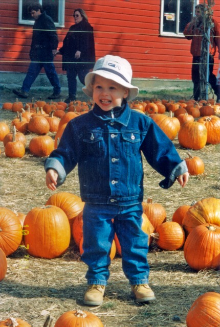 Toddler in blue coat on a Hudson Valley pumpkin and apple farm