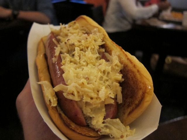 Image of the Shake Shack special Shacktoberfest Sausage dog, wrapped in a hot dog bun and topped with sauerkraut