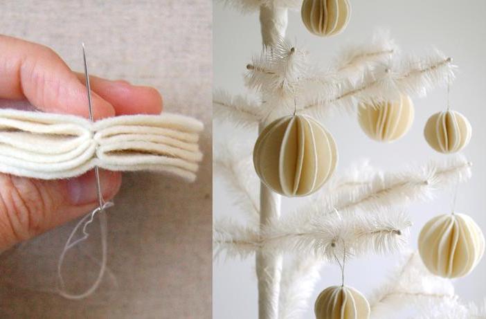 Close up of someone sewing felt together to make white ornamets to hang on their christmas tree