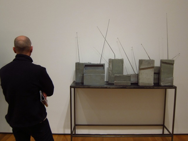Man standing in front of Isa Genzen's concrete radio sculptures