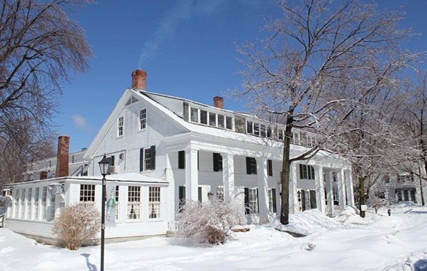 A large white house, called the Dorest Inn, in a snow covered town
