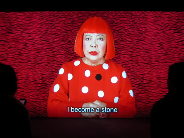 Artist Yayoi Kusama wears a read wig and a red and white spotted shirt in her video entitled "Manhattan Suicide Addict"