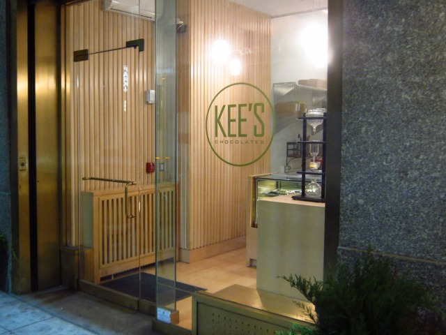 Outside of the midtown location of Kee's Chocolates, you can see in through the window at the display cases filled with chocolate