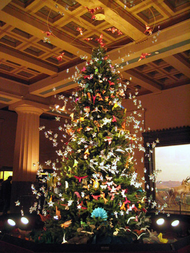 Image of the christmas tree in the museum of natural history, with beautiful ornaments that seem to be flying around the pine tree