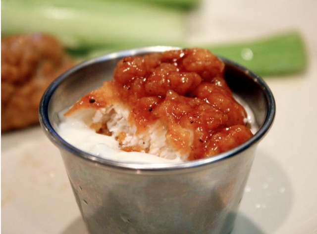 Boneless chicken wings, bitten in half and dunking in a side of blue cheese