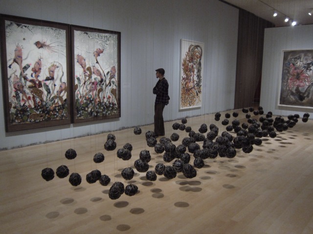 A man walking through the Brooklyn Museum admiring the Wangechi Mutu pieces