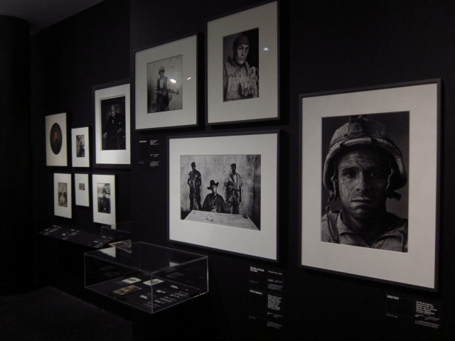 Black painted wall with black and white framed photography of War at the Brooklyn Museum in NYC