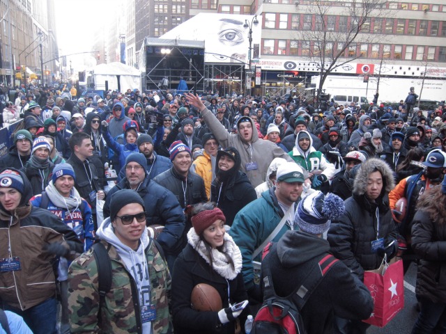 In Times Square NYC, crowds of New Yorkers and tourist wait in line to get something autographed by NFL players