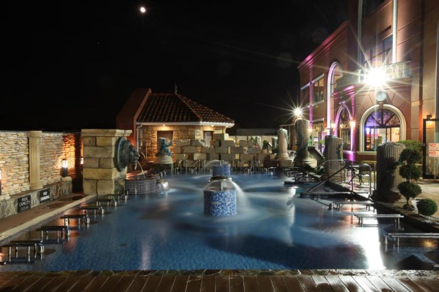 The outdoor pool area of Spa Castle in NYC, with a large pool, hot tubs, and saunas to relax in