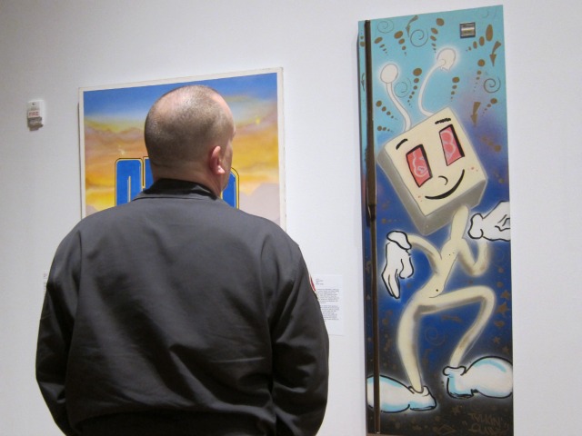 A man stands in front of some graffiti pieces at the Museum of the City of New York