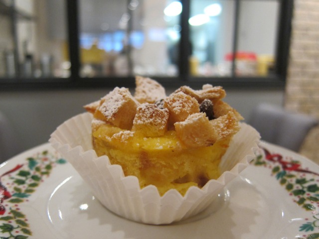 O'merveilleux's Belgian bread pudding dish sitting on a plat in a paper cupcake holder