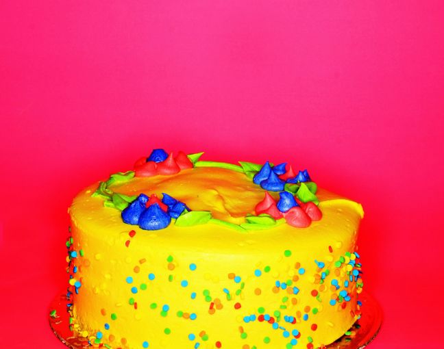Yellow birthday cake with colored decoractions, one of the sculptures at ArtFair in NYC