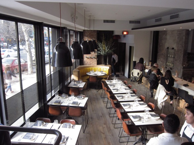 several tables looking out of a window onto the street at Charlie Bird in SOHO