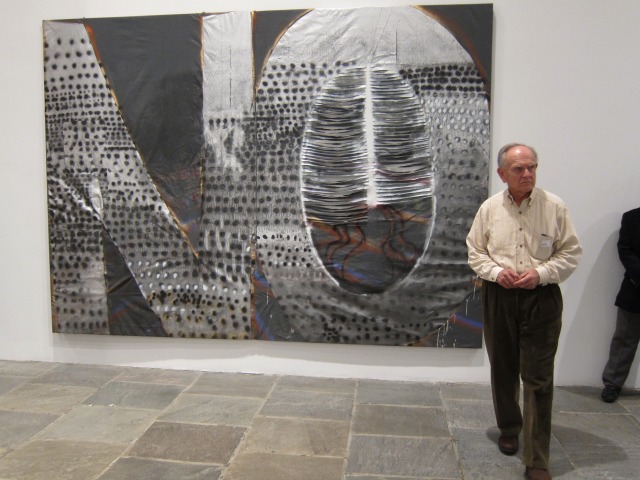 Man standing in front of a giant painting with the word "NO" on it at the Whitney Biennial