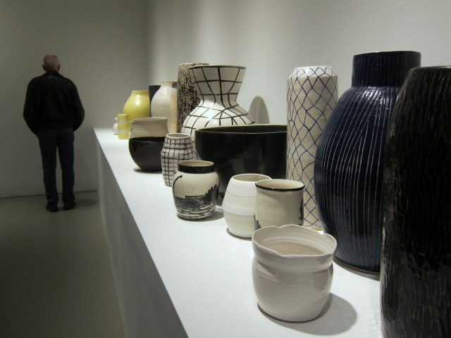 A white table with different shapes and size of pottery