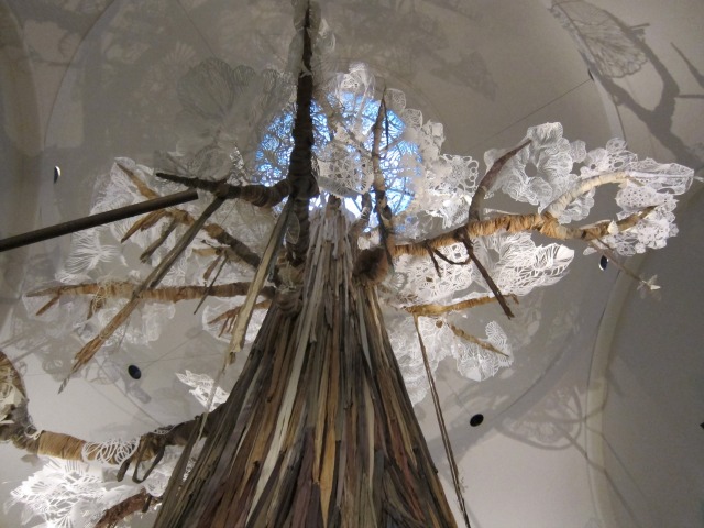 Looking up at Swoon's towering sculptural tree, hand-crafted from NYC garbage boats