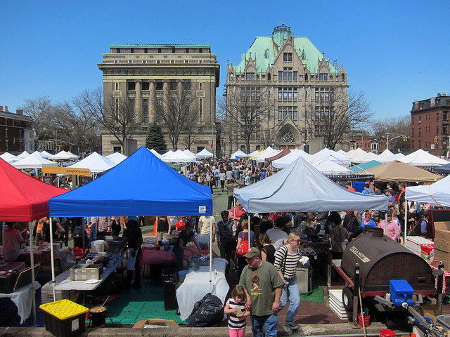 Image of the Brooklyn Flea market at Fort Greene in NYC with hundreds of vendor tents set up and people walking around