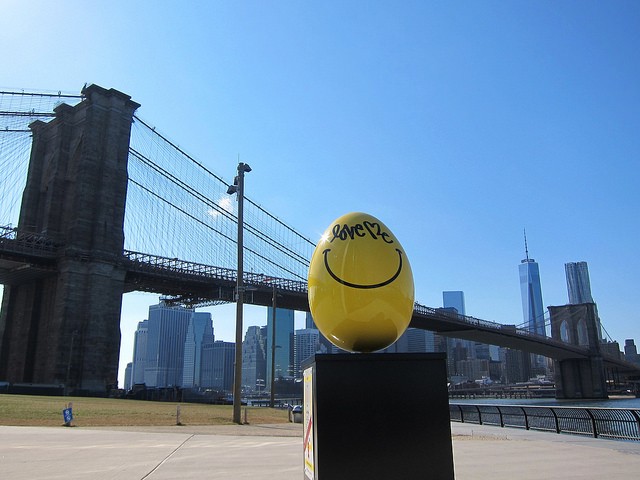 Yellow sculptured egg with smiley face near the Brooklyn Bridge as part of the Big Egg Hunt