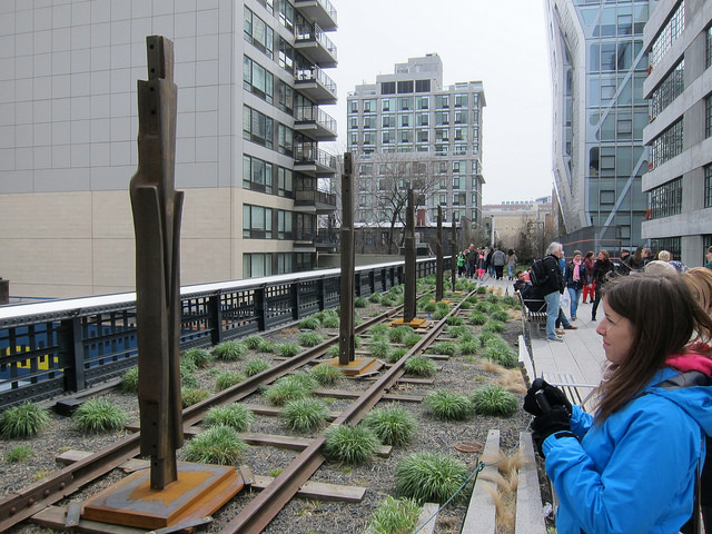 People stop to admire the public art exhibition at the High Line called Archeo