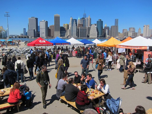 Image of the Smorgasburg at Brooklyn Bridge Park in NYC with hundreds of vendor tents set up and people walking around