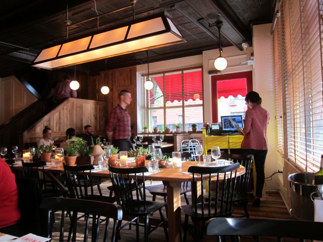 An inside shot of servers and patrons inside Andrew Carmellini's Bar Primi restaurant