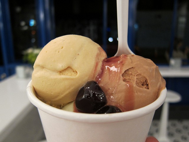 Two scoops of ice cream sit in a cup with juicy Luxardo cherries from Moregenstern's Finest Ice Cream - a brand new ice cream parlor in NYC.