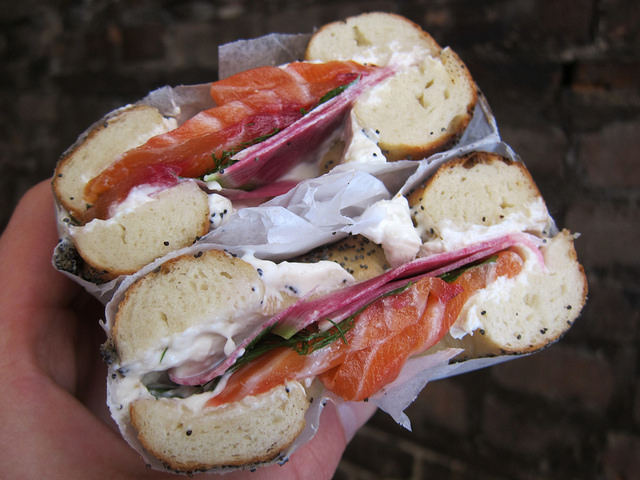 Close up image of a Black Seed Montreal-style bagel topped with cream cheese and beet-cured salmon.