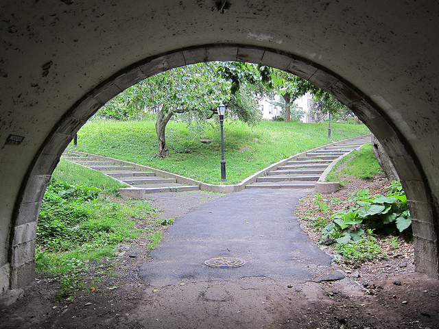 In the tunnel of Riverside Park in NYC looking at the greenery and stairs going up to the streets