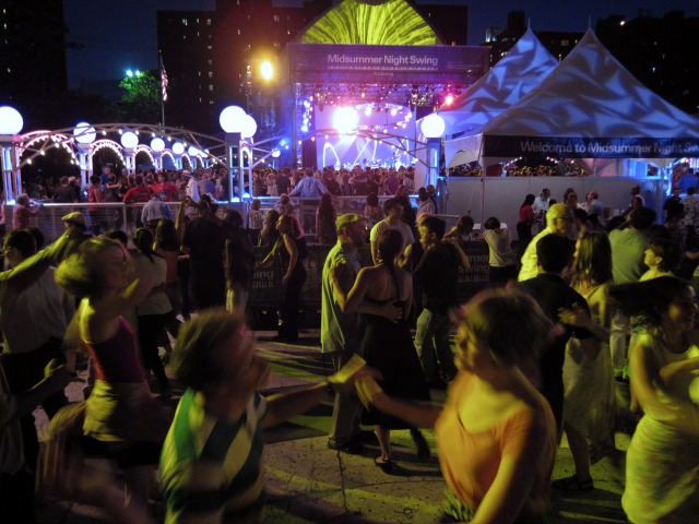 Crowds of dancing people enjoy the music and culture of Midsummer Night Swing at Lincoln Center