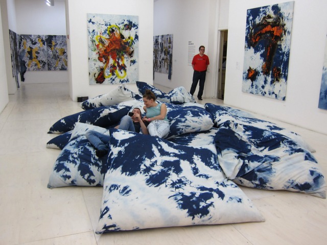 An image of  two people laying in Korakrit Arunanondchai's Pillow Room at MoMA PS1