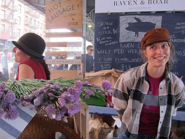 One of the vendors, called Raven & Boar, for the New Amsterdam Market smiling and helping customers.