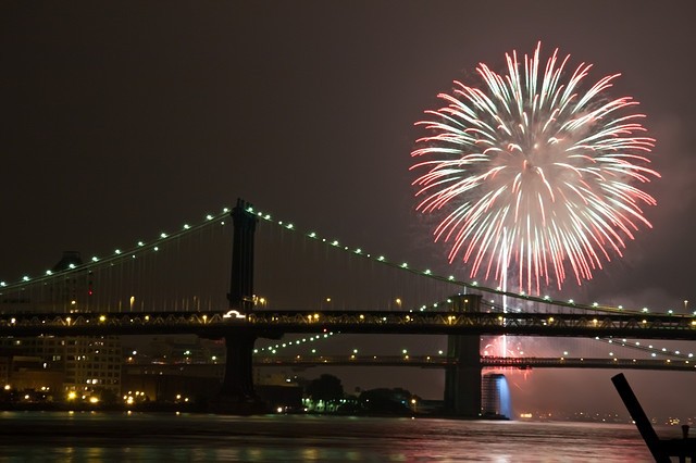 Image of the 4th of July fireworks blast off in the sky right above the Brooklyn Bridge