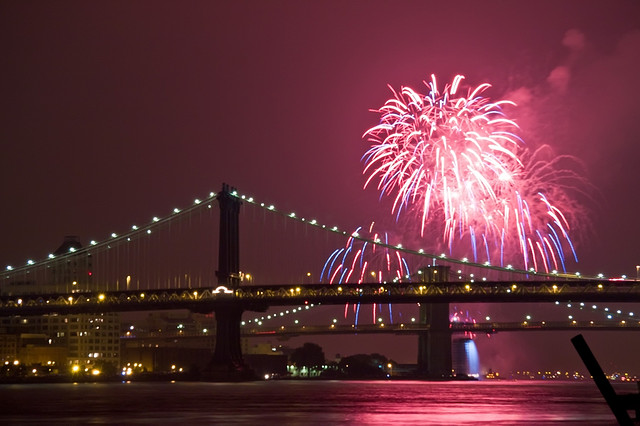 Bright pink fireworks light up the sky on the 4th of July right above the Brooklyn Bridge