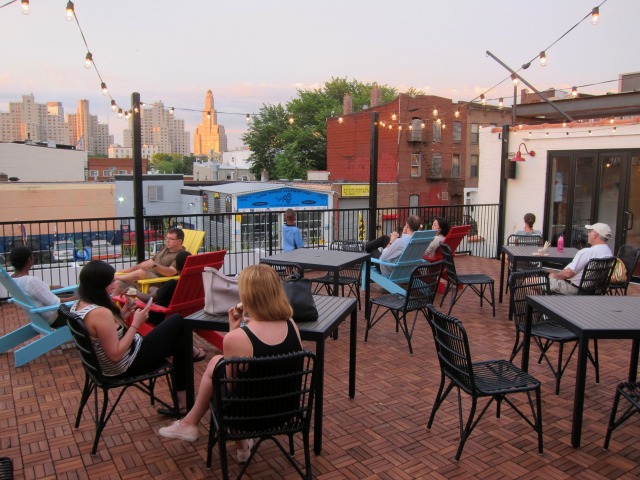 People seated outside on the roof deck of the newly-opened Ample Hills Creamery in Gowanus