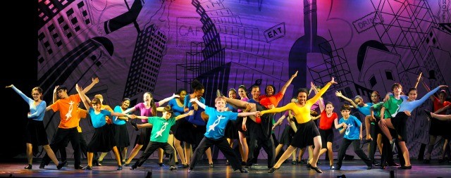 Actors in colorful shirts perform the finale in a production at the  National Dance Institute