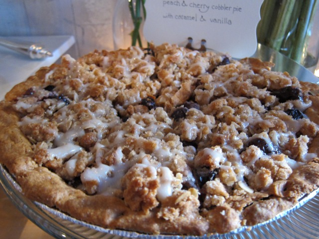 Image of a cherry cobbler flavored pie topped with caramel and vanilla