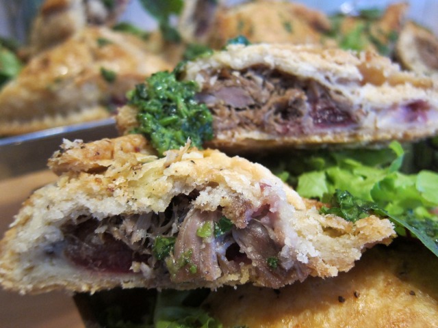 Image of mini duck pies cut in half to see the crunchy crust and the slow cooked duck inside.