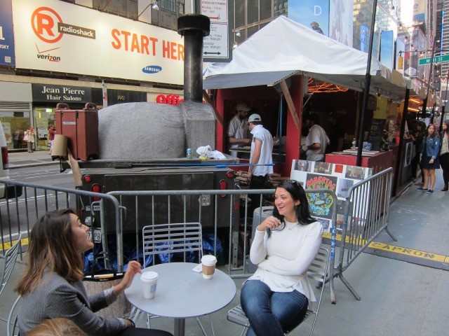 Two friends enjoying coffee at UrbanSpace's pop-up market in Midtown.