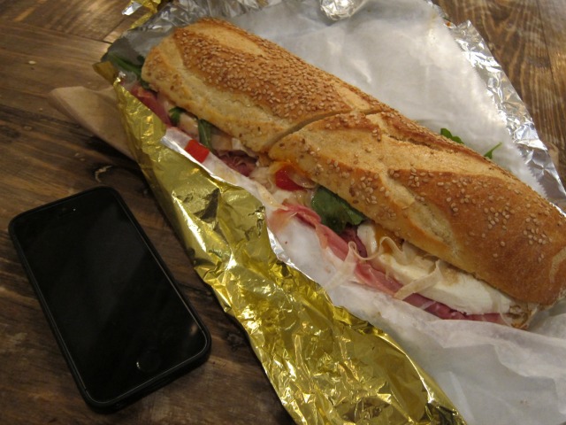 An Alidoro sandwich next to an iPhone 5 to show the size of the sandwich