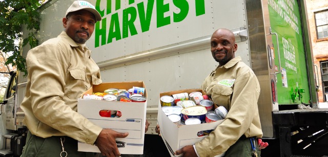 Volunteers from City harvest showing off their collection of canned goods for Thanskgiving