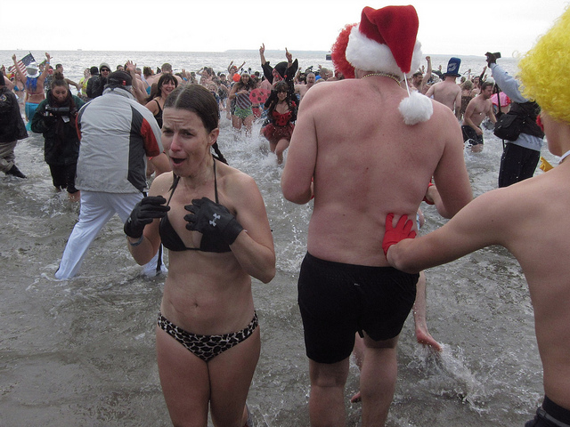 A woman emerges from the cold water after participating in the Polar Bear Plunge
