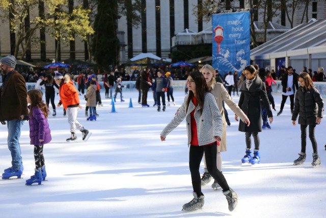 Ice skaters at the Bryant Park free ice skating rink in NYC.
