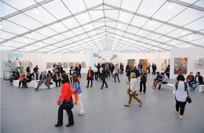 crowd of people walking through an exhibit, examining artwork