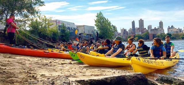 An instructor teaching a class of kayakers at Long Island City Community Boathouse.