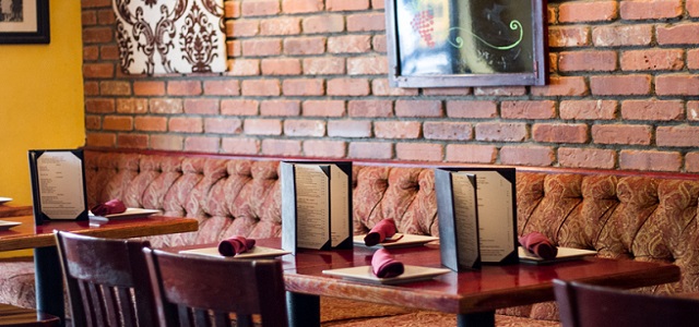 Sunlight shines on exposed brick walls and rustic colored decor inside Riposo Wine Bar.