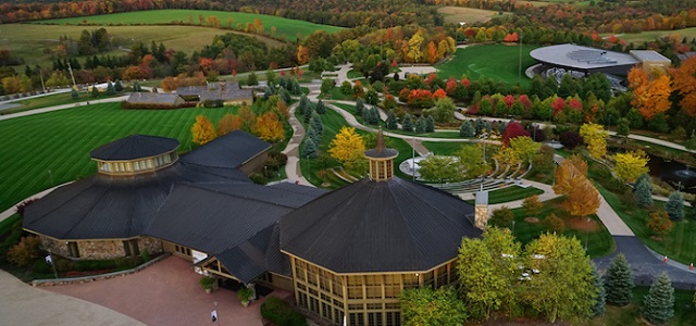 An aerial view of Bethel Woods Center for the Arts in the fall with green grass and colorful autumn leaves changing surrounding the sidewalks and buildings.