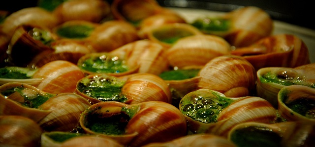 A fresh and hot serving of bubbling green escargot in the shell.