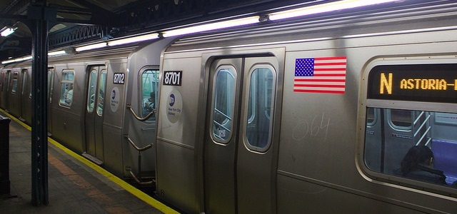 A train with an american flag inside a subway station in New York City. 