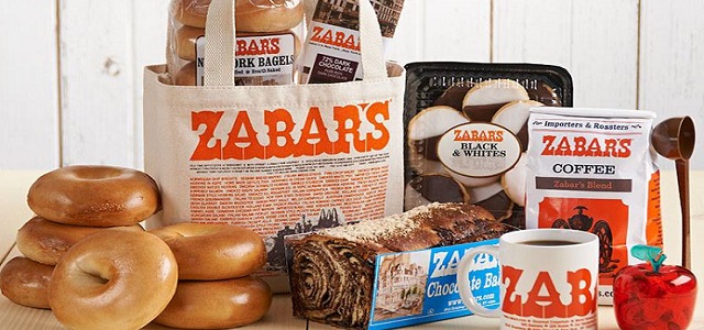 A picnic basket and reuseable bag from Zabar's with freshly baked bagels, black and white cookies, a bag of ground coffee and freshly baked bread.