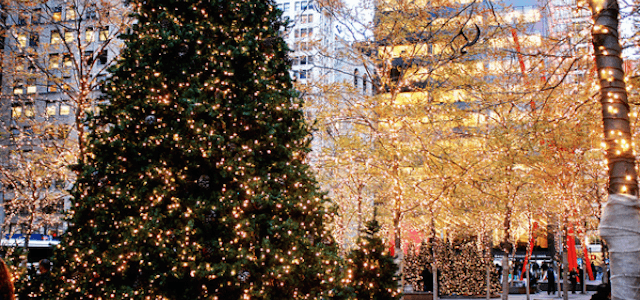 An outside view of a decorated Christmas tree in New York City with golden yellow lights.